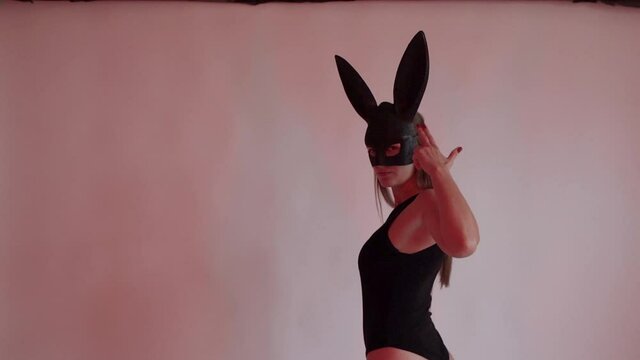 Sexy woman in hare mask posing and gesturing at camera