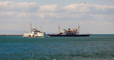 The traditional ships of Istanbul are sailing towards each other. Ferry and car carrying ferry are sailing in Istanbul strait.