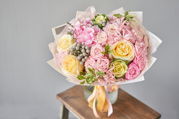 Beautiful spring bouquet on wooden table.. Arrangement with various flowers. The concept of a flower shop. A set of photos for a site or catalogue. Work florist.
