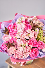 purple and pink bouquet with the flower of the artichoke. Beautiful flowers on wooden table. Floristry concept. Spring colors. the work of the florist at a flower shop.