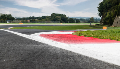 Motor sport circuit asphalt track background curb close up on straight and green field