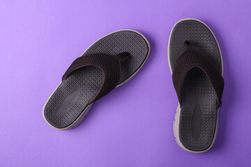 Brown flip flops on blue background. Top view with copy space.