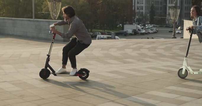 Couple having fun riding on electric scooter in city