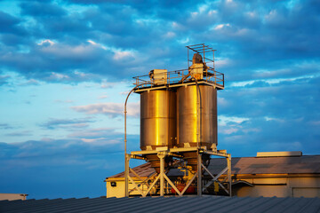 Obraz premium storage tanks made of metal cylindrical shape on the roof of an industrial building.Oil storage tanks at a petrochemical plant. Petroleum products processing plant. Industrial view of the factory area