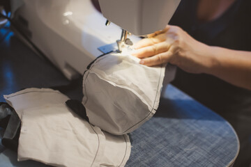 Handmade mask sewing from the fabric is used to prevent spread disease outbreaks from coughing or sneezing with dust in the air and germs close-up.