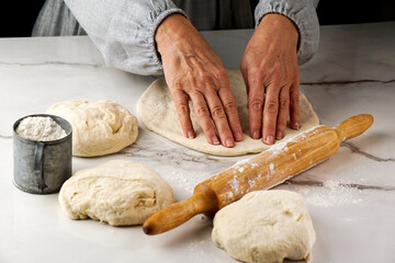 making pizza process, woman's hand working with dough and flour, white and grey background