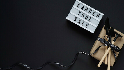 Banner concept for Black Friday celebration,lettering.White board with text GARDEN TOOL SALE, gift...