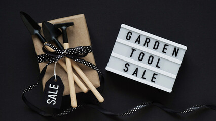 Banner concept for Black Friday celebration,lettering.White board with text GARDEN TOOL SALE,gift...