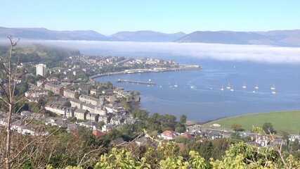 Fototapeta na wymiar Sweeping panoramic view over Gourock and the Firth of Clyde from Lyle Hill. Some mist in patches close to the water.