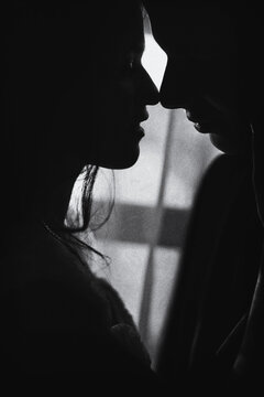 black and white photo. Silhouette a young couple holding each other. soft focus, loud noise.