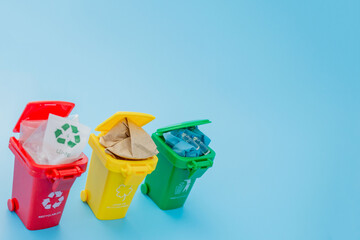 Yellow, green and red recycle bins with recycle symbol on blue background. Keep city tidy, Leaves the recycling symbol. Nature protection concept