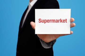 Supermarket. Businessman in suit showing business card with text. Man isolated on blue background