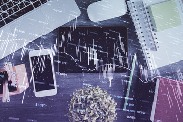 Double exposure of forex chart hologram over desktop with phone. Top view. Mobile trade platform concept.