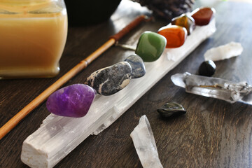 A close up image of seven chakra healing crystals charging on a selenite wand. 