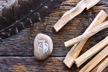 A top view image of a reiki healing symbol and palo santo smudge sticks on a dark wooden table top.  - obrazy, fototapety, plakaty