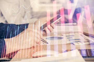 Double exposure of man's hands holding and using a digital device and forex graph drawing. Financial market concept.