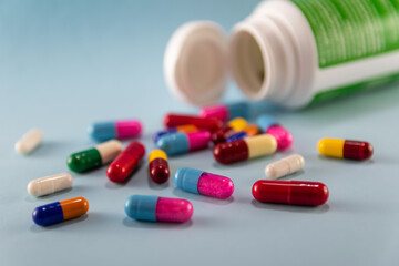 image of multicolored pills and bottle on blue