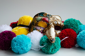 Máscara Veneciana sobre bolas de lana de colores. Foto de una máscara Zanni italiana con...