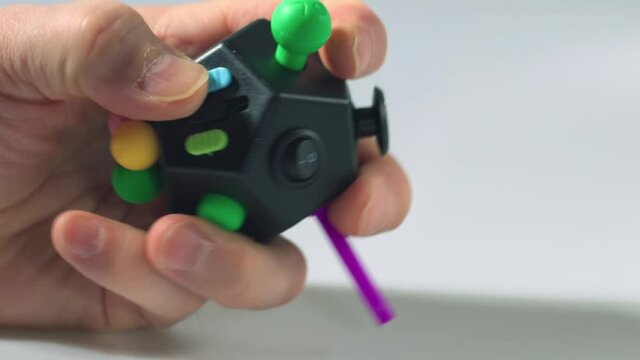Close up view of colorful anti stress toy in man's hand. Stress and health concept.