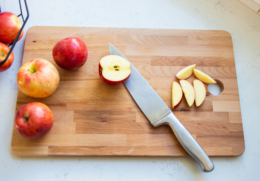Apples on a wooden cutting board with knife