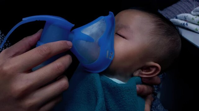 Cute Asian baby getting treatment using nebulizer for asthma