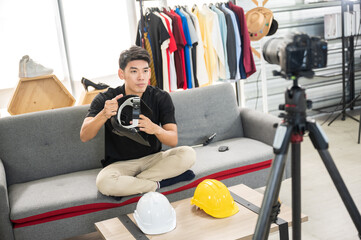 Young man recording video vlog on a digital camera and computer labtop. Smiling male present online marketing for sell