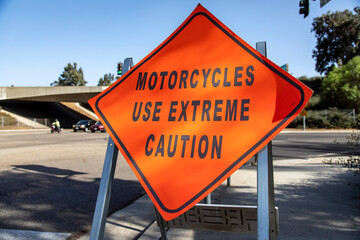 A diamond shaped road sign advising motorcyle riders to use extreme caution