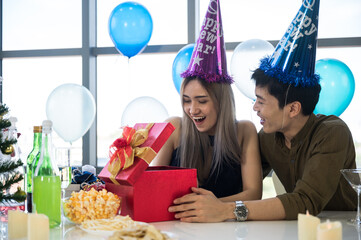 Surprised young couple lover for birthday and Valentine. Hold red present box with gift ribbon bow and balloon.