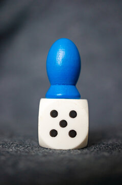 Vertical Shot Of Dice With A Blue Wooden Figure On It