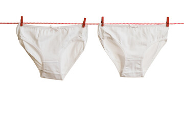 White underpants on a red and white rope with red clothespins.