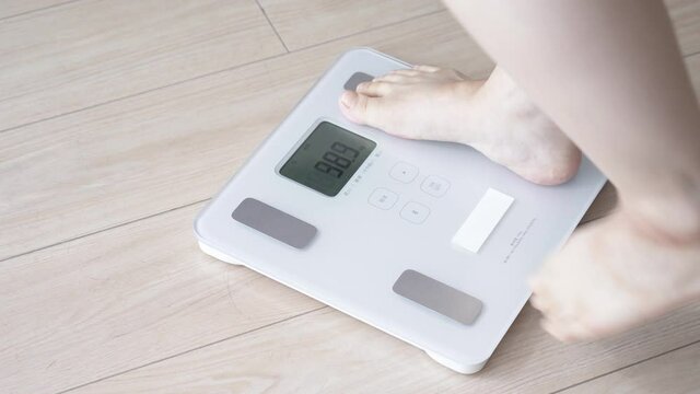 体重計に乗る女性　パン