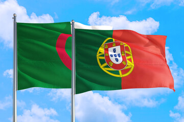 Portugal and Algeria national flag waving in the windy deep blue sky. Diplomacy and international relations concept.