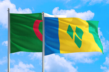 Saint Vincent And The Grenadines and Algeria national flag waving in the windy deep blue sky. Diplomacy and international relations concept.