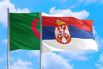 Serbia and Algeria national flag waving in the windy deep blue sky. Diplomacy and international relations concept.