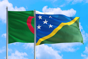 Solomon Islands and Algeria national flag waving in the windy deep blue sky. Diplomacy and international relations concept.