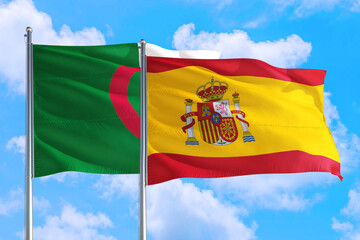 Spain and Algeria national flag waving in the windy deep blue sky. Diplomacy and international relations concept.