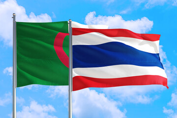 Thailand and Algeria national flag waving in the windy deep blue sky. Diplomacy and international relations concept.