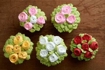 cupcakes decorated with rose design chantilly, placed on a wooden base