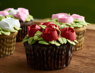cupcakes decorated with rose design chantilly, placed on a wooden base