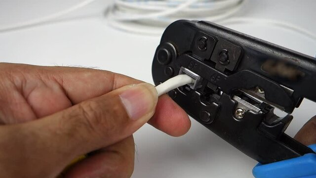 Crimping RJ-45 connector of a network cable.