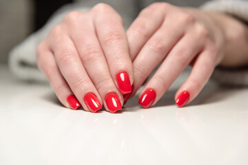 hands of a young girl with red manicure