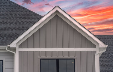 White frame gutter guard system, with dark gray horizontal vinyl siding, white accents, fascia,...