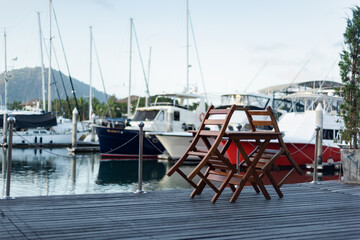 restaurant on the waterfront. A table on the waterfront. Closed restaurant on a deserted promenade. lagoon without people. Phuket Boat Lagoon. Thailand.