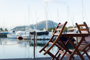 restaurant on the waterfront. A table on the waterfront. Closed restaurant on a deserted promenade. lagoon without people. Phuket Boat Lagoon. Thailand.