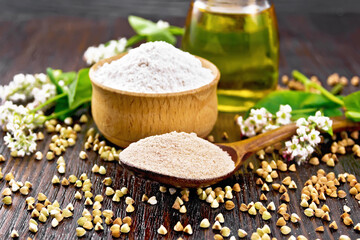 Flour buckwheat brown in spoon with oil on board