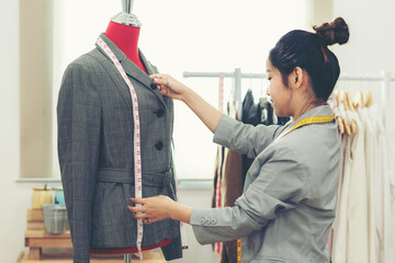 Work from home. Asian young woman fashion designer  working on her design in the showroom. ...