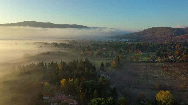 suggestiva ripresa aerea con drone controluce volando sopra una fitta nebbia