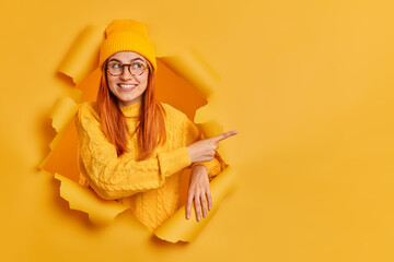 Good looking cheerful millennial girl with tender smiles advertises something suggests discounts...