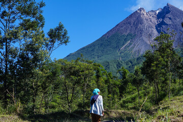 Fototapeta na wymiar A woman is looking at Mount Merapi