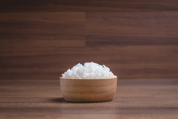 Cooked jasmine rice in wooden bowl in on wooden table. Thai Jasmine rice.